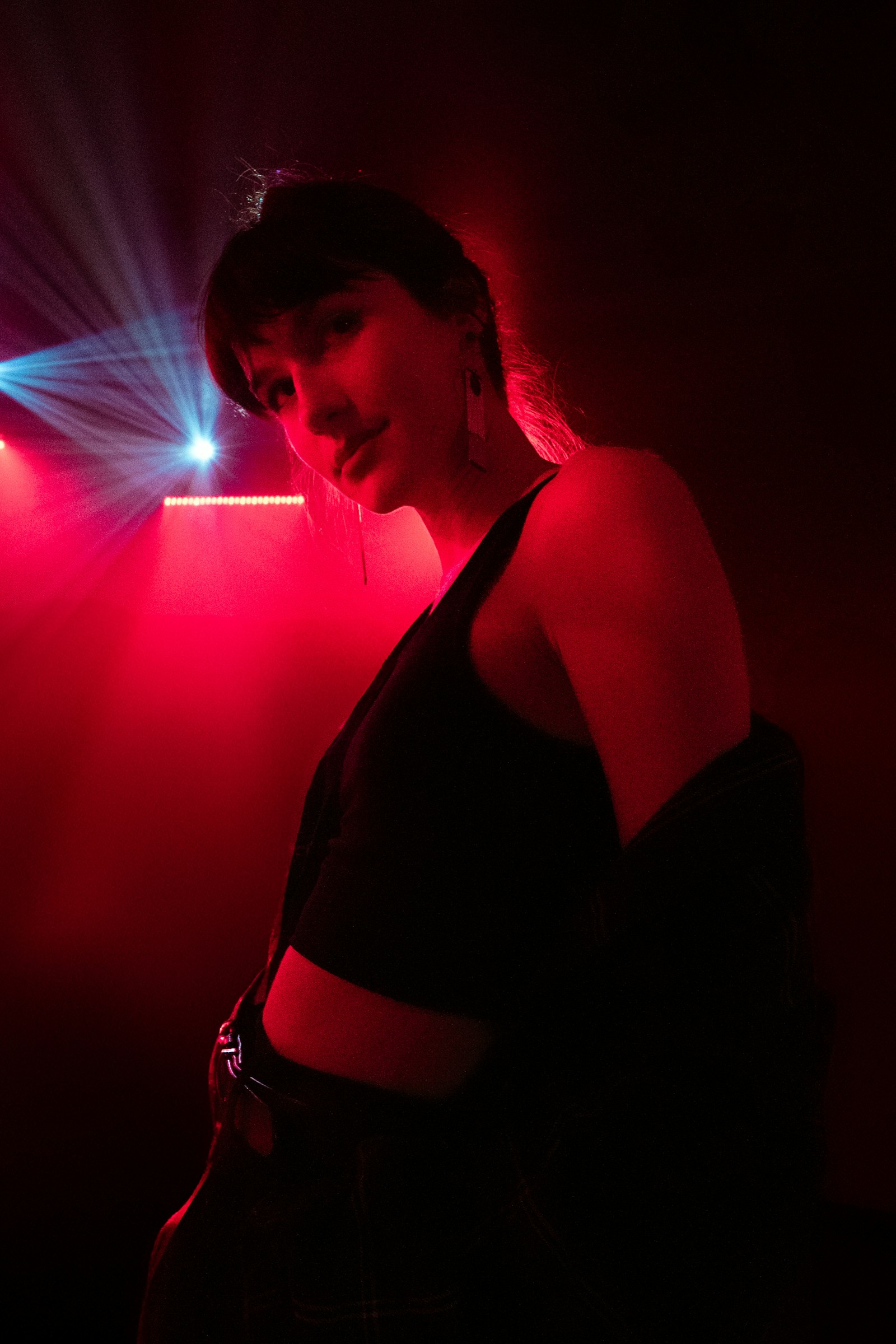 Confident person posing in dramatic red and blue neon light